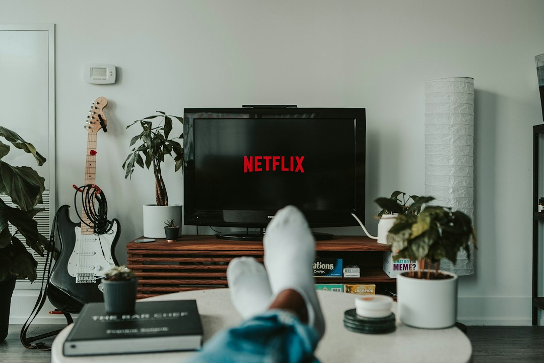Pessoa assistindo conteúdo em uma televisão na sala